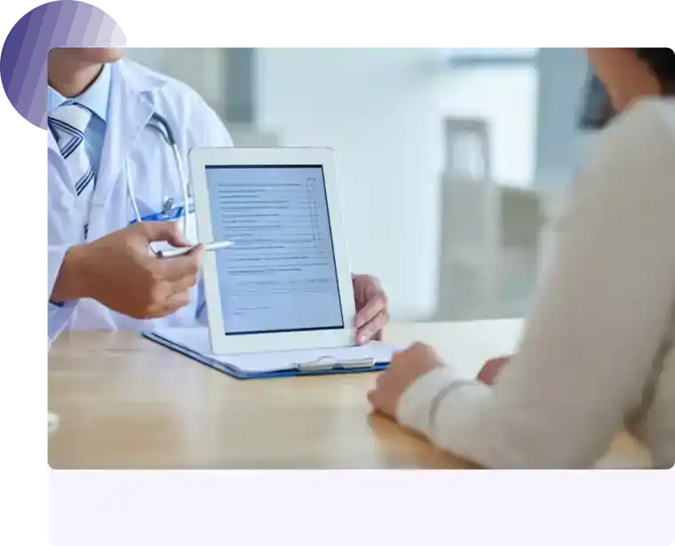 Doctor reviewing documents on a tablet with a patient